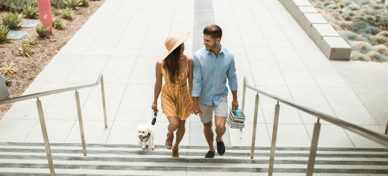 A man and a woman walking upstairs with their dog, talking about the best places to live in Missouri.