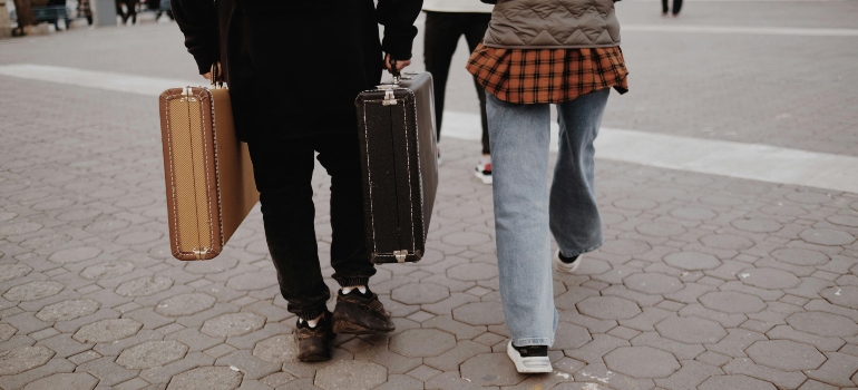 A couple are walking with suitcases, thinking about the best places to live in Missouri.