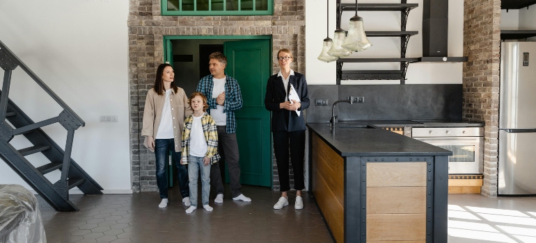 An agent is touring around the family inside the house.