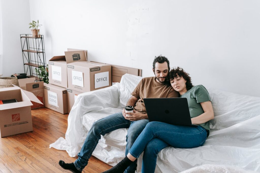 a couple sitting and looking at laptop and deciding between packing services vs DIY packing