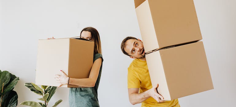 a couple struggling with moving boxes while waiting for University City movers