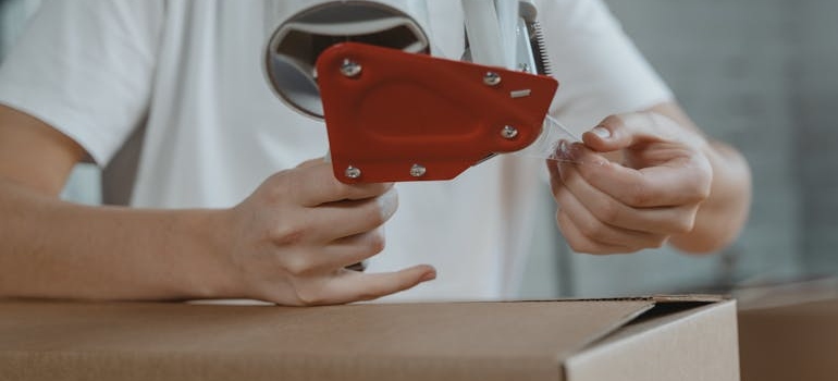 a person taping a box 