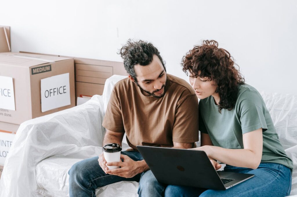 a couple reading about University City movers on their laptop